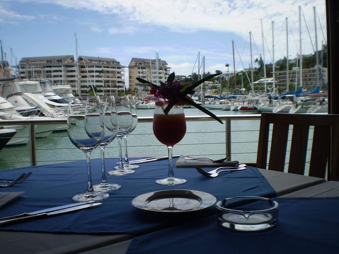 Une table dressée face à la marina, un cocktail au bord de l’eau